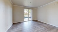 Located at 3401 Savannah Ln in West Sacramento, CA, this single-floor residence offers three bedrooms and three full bathrooms in a well-organized layout. Light wood-style flooring runs throughout, lending a clean, cohesive feel to every room. The living room is bright and open, with crown molding accents and a sliding glass door that leads to a private balcony overlooking lush greenery — an inviting spot that brings natural light and outdoor views into the heart of the home. The kitchen features warm, rich wood cabinetry in a practical U-shaped layout with a breakfast bar peninsula that opens toward the living area. White appliances, including a refrigerator, electric range, and dishwasher, complement the neutral countertops. Each of the three bedrooms offers a comfortable footprint, with windows fitted with vertical blinds that provide both natural light and privacy. The primary bedroom includes built-in closet cabinetry with rich wood-toned doors. The three bathrooms are functional and consistent in style, each featuring wood-toned vanity cabinetry, light countertops, and tub-shower combinations. A connecting hallway ties the layout together efficiently. The overall palette of warm neutrals and wood tones creates a calm, livable ambiance throughout.