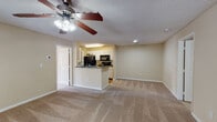 This well-appointed 2-bedroom, 2-bathroom residence in Savannah, GA offers a comfortable and functional single-floor layout. The open-concept living and dining area is generously sized, featuring plush wall-to-wall carpeting, neutral warm-toned walls, and a ceiling fan with integrated lighting. Natural light filters in through multiple windows, and a glass-panel door provides access to an outdoor area.

The kitchen is fully equipped with black appliances, including a refrigerator, electric range, microwave, and dishwasher. White cabinetry with granite-style countertops lines both sides of the galley-style layout, complemented by warm hardwood flooring. A peninsula connects the kitchen to the living area, offering additional counter space and an open sightline throughout.

Both bedrooms are carpeted and feature ceiling fans, neutral walls, and windows with blinds that allow for natural light and privacy. Each room offers ample space for furnishings.

The two full bathrooms are finished with white vanity cabinetry, granite-style countertops, large mirrors, and combination tub/shower units. Hardwood flooring adds a classic touch to the bathroom spaces. The overall ambiance of this residence is clean, neutral, and move-in ready.