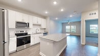 Located at 6120 Burnett St in Lakeland, FL, this well-appointed 1-bedroom, 1-bathroom unit offers a thoughtfully designed single-floor layout that maximizes both comfort and functionality. The open-concept kitchen flows seamlessly into the living area, creating a bright and connected living space. The kitchen is a standout feature, showcasing white shaker cabinetry, granite countertops, a large central island, and stainless steel appliances including a refrigerator, range, microwave, and dishwasher. Recessed lighting and wood-look flooring enhance the modern aesthetic throughout the common areas. The spacious living room is bathed in natural light from a large window and is finished with a ceiling fan for year-round comfort. The bedroom offers plush carpeting, a ceiling fan, and a window with outdoor views, creating a calm and restful retreat. The bathroom features granite countertops, a framed mirror, white cabinetry, and a tiled tub-shower combination. A dedicated laundry room with a full-size washer and dryer adds significant convenience. A closet provides additional storage, completing this efficient and modern unit.