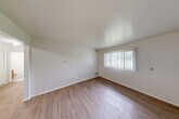 Located at 303 Smith St in Clio, Michigan, this single-floor, one-bedroom, one-bathroom unit offers a practical and well-organized layout. The living room is bright and welcoming, featuring warm wood-look flooring, clean white walls, and a large window dressed with vertical blinds that allows natural light to fill the space while offering views of the outdoors.

The kitchen and dining area flow together seamlessly, making efficient use of the available space. The kitchen is equipped with rich wood-toned cabinetry, light countertops, a double sink, a dishwasher, a range, a refrigerator, and a microwave — providing a full suite of appliances. The tile-style flooring in the kitchen transitions neatly into the wood-look flooring of the adjoining dining and living areas.

The bedroom is a comfortable and quiet retreat, finished with plush carpeting, white walls, and a window with vertical blinds for natural light. A panel door leads to closet storage, and the room connects easily to the hallway. The unit includes a notable four closets in total, offering generous storage throughout.

The bathroom features a full tub and shower enclosure with clean white finishes. A hallway connects the main living spaces to the bedroom and bathroom, creating a logical and efficient flow throughout the home.