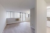 Located at 935 Dundas St E in Mississauga, this 2-bedroom, 1-bathroom unit offers a well-organized, single-floor layout designed for comfortable everyday living. The open living and dining area is bright and airy, featuring large windows with vertical blinds that allow generous natural light to fill the space. A ceiling fan, wall-mounted air conditioning unit, and baseboard heating ensure year-round comfort. Light-toned laminate flooring runs throughout, creating a clean and cohesive aesthetic. The kitchen is efficiently designed with crisp white shaker-style cabinetry, ample upper and lower storage, a double sink, and white appliances including a stove and refrigerator, all beneath bright overhead lighting. The primary bedroom offers a comfortable footprint with a built-in closet, a window for natural light, and direct access to the shared bathroom. The second bedroom is a cozy, well-lit space with its own window and baseboard heating. The bathroom features a white vanity with storage, a mirrored medicine cabinet, and a shower-tub combination. A dedicated closet provides additional storage. The unit's neutral colour palette and functional design make it a practical and inviting living space.