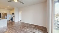 Located in Northlake, Texas, this single-story 2-bedroom, 2-bathroom residence offers a thoughtfully designed layout with modern finishes throughout. Wood-style plank flooring flows continuously across all living areas, complemented by neutral-toned walls and ceiling fans in each room.

The combined kitchen and living area serves as the heart of the home. The kitchen is equipped with stainless steel appliances — including a refrigerator, range, and microwave — white shaker-style cabinetry, granite countertops, a central island with an undermount sink, pendant lighting, and open wall shelving for additional storage. The living area is bright and open, with sliding glass doors leading to a private balcony with outdoor views.

Both bedrooms are well-sized, each featuring a ceiling fan and access to closets. The primary bedroom includes an en-suite bathroom with a walk-in closet, granite vanity, and a glass-enclosed marble-tiled shower. The second bathroom offers a marble-tiled soaking tub and shower combination, along with a granite vanity. A dedicated hallway connects the rooms, contributing to a logical and functional floor plan. The clean, modern aesthetic and quality finishes make this a comfortable and practical living space.