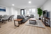 Located at 99 Milford Ave in Waterloo, Ontario, this thoughtfully designed 3-bedroom, 1-bathroom unit offers a well-organized single-floor layout that maximizes every inch of its compact footprint. The open-concept living and dining area serves as the heart of the home, featuring light hardwood-style flooring, recessed lighting, and a striking white sliding barn door that adds both a functional and decorative element to the space. A glass-top dining table and comfortable seating area flow seamlessly toward a private entrance with windows that invite natural light.

The kitchen is sleekly finished with two-tone cabinetry—warm wood lower cabinets paired with crisp white uppers—complemented by white quartz countertops, a tile backsplash, and a full suite of stainless steel appliances. A hallway connects the living areas to three bedrooms, each finished in neutral tones with windows providing natural light. The primary bedroom offers a calm, restful atmosphere, while the additional bedrooms are efficiently sized.

The bathroom features a wood-toned vanity with a white quartz countertop and is conveniently situated near an in-unit stacked washer and dryer, adding practical everyday functionality to this well-appointed Waterloo residence.