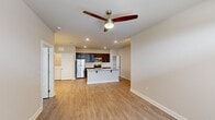 This single-story unit in Lake Charles, Louisiana, offers a thoughtfully designed open-concept layout that maximizes its comfortable footprint. Light-toned walls and wood-look plank flooring run consistently throughout the space, creating a cohesive and clean aesthetic.

The combined kitchen and living area forms the heart of the unit. The kitchen is outfitted with rich, dark espresso cabinetry, granite-style countertops, a white subway tile backsplash, and a full suite of stainless steel appliances, including a refrigerator, electric range, and microwave. A kitchen island with seating provides additional prep and dining space. Recessed lighting and a ceiling fan enhance the living area, which opens to the exterior through a set of French doors topped with a transom window, inviting abundant natural light.

The bedroom is a well-proportioned retreat featuring a ceiling fan with light, a window with blinds, and direct access to a dedicated closet. Neutral wall tones and wood-look flooring continue throughout. The bathroom is naturally lit by a window and connects conveniently to the closet space, offering a practical layout. The unit's design balances functionality and modern finishes throughout.