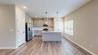 This well-appointed two-story home in Cartersville, Georgia offers a thoughtfully designed layout spread across two floors. The main level features an open-concept kitchen and living area, where light wood-look tile flooring flows seamlessly throughout. The kitchen stands out with granite countertops, gray shaker-style cabinetry with matte black hardware, stainless steel appliances including a gas range and French door refrigerator, and a center island with pendant lighting. The living room is bright and airy, featuring a ceiling fan, French doors that invite natural light, and views of the outdoors. An attached garage with a dedicated opener system provides convenient access. Upstairs, three bedrooms are finished with plush neutral carpeting and windows that bring in natural light. The generously sized primary bedroom offers a comfortable retreat. Three full bathrooms are distributed across the home, each featuring wood-look tile floors, gray vanity cabinetry, and clean white fixtures. Secondary bathrooms include a tub-shower combination, while another features a streamlined vanity layout. Neutral warm-toned walls throughout the home create a cohesive, move-in-ready atmosphere well suited for everyday living.