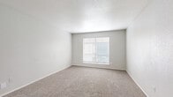 Located at 6500 W 43rd St in Houston, Texas, this single-floor unit offers six bedrooms, two closets, a shared hallway, and one full bathroom within a compact yet efficiently arranged floor plan. The entry area features durable wood-look flooring that transitions into plush carpeting found throughout the bedrooms and common areas, creating a warm and consistent interior aesthetic. Neutral gray-toned walls and white trim are consistent throughout, lending the space a clean, move-in-ready appearance. Each bedroom is bathed in natural light courtesy of windows fitted with horizontal blinds, and several rooms are equipped with ceiling fans for added comfort and airflow. The spacious primary bedroom offers generous room to furnish, with a closet and open access to the hallway. Additional bedrooms vary in size but maintain the same bright, carpeted layout. A connecting hallway links the bedroom wing to the rest of the unit. The shared bathroom features wood-look tile flooring, a single-sink vanity with a light countertop, white cabinetry, a full-size tub-shower combination with tan tile surround, and a large mirror. The overall layout, as seen in the dollhouse view, is straightforward and practical, making this a functional multi-bedroom unit suitable for shared living arrangements.