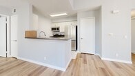 Located at 21311 Alder Dr in Santa Clarita, CA, this single-story 2-bedroom, 2-bathroom home offers a clean, modern aesthetic throughout. The living area stands out with impressively tall ceilings, light wood laminate flooring, and an abundance of natural light streaming through vertical-blind-covered windows and a sliding glass door that opens to an outdoor patio. A transom window above the entry door adds additional brightness to the welcoming entryway.

The kitchen features a peninsula with a dark quartz-style countertop, white cabinetry, stainless steel appliances including a gas range, microwave, and refrigerator, and light tile flooring—offering both style and functionality. The space flows naturally into the living and dining areas.

Both bedrooms continue the light wood flooring theme, with soft neutral wall tones and windows fitted with vertical blinds that allow for flexible natural light. The primary bedroom provides a comfortable, well-proportioned retreat. A dedicated closet offers organized storage.

The two bathrooms are finished with white tile flooring, white cabinetry with dark countertops, and full tub-shower combinations, maintaining a consistent, clean aesthetic. Overall, this home presents a bright, modern, and functional living environment well-suited to its sunny Southern California setting.