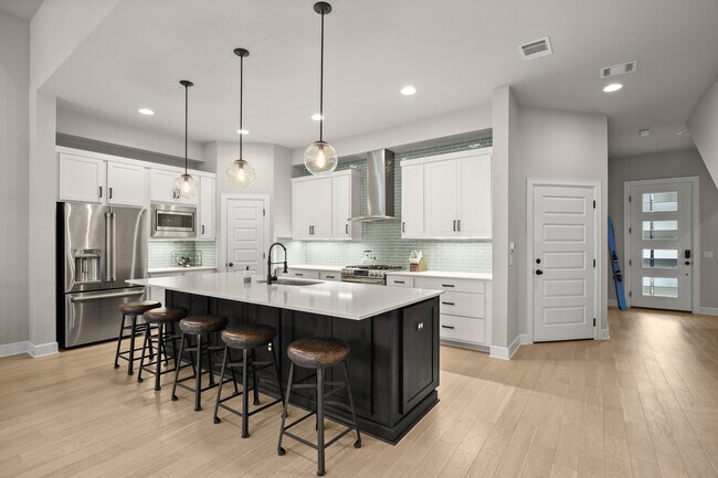 Kitchen includes gas range and oven, large pantry, and island comfortably seating five. - 1003 Cardinal Ln