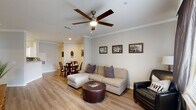 This thoughtfully designed 2-bedroom, 2-bathroom residence in Baton Rouge, Louisiana delivers a comfortable and functional single-story layout with modern finishes throughout. Light wood-tone flooring flows seamlessly across the main living areas, complemented by crown molding and neutral wall tones that create a warm, cohesive aesthetic.

The open-concept living and dining area is a welcoming centerpiece, featuring a ceiling fan with integrated lighting, large windows that invite natural light, and direct sightlines to the dining space. The kitchen is well-appointed with white shaker cabinetry, granite-style countertops, a subway tile backsplash, and a full suite of stainless steel appliances, including a range, built-in microwave, and dishwasher. A pass-through connects the kitchen to the dining area for easy entertaining.

Both bedrooms are generously sized, each featuring ceiling fans, large windows, and walk-in closets with built-in shelving. The primary bedroom includes access to a private outdoor area through sliding glass doors. The two bathrooms are finished with granite countertops, white cabinetry, and a tub-shower combination. A well-organized hallway with multiple doors connects the bedrooms and bathrooms, adding to the home's practical layout.