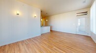 Located at 5959 Dunkirk St in Denver, CO, this single-floor, 3-bedroom, 2-bathroom home offers a thoughtfully designed layout with consistent hardwood-style flooring throughout. The kitchen is a functional standout, featuring warm maple cabinetry, granite-style countertops, a full suite of stainless steel appliances including a range, over-the-range microwave, and refrigerator, plus a pendant light accent and a double-basin sink. The open hallway connects the main living areas seamlessly, drawing natural light from the bright living room, which is lined with large windows fitted with vertical blinds that offer ample sunlight and exterior views. The three bedrooms are clean and neutral, with warm-toned flooring and natural light. The primary bedroom provides a generous footprint with dedicated closet space. Both bathrooms are finished with wood-toned vanities and white countertops. A dedicated laundry room includes a washer and overhead cabinetry for added storage. Four closets throughout the home ensure excellent storage capacity. A private balcony rounds out this well-organized home, offering an outdoor retreat within this Denver community.
