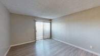 Located at 4400 Elkhorn Blvd in Sacramento, CA, this 2-bedroom, 1-bathroom single-floor unit offers a practical and well-appointed layout throughout. The living room is bright and open, featuring light-toned luxury vinyl plank flooring and a sliding glass door fitted with vertical blinds that invite natural light and provide outdoor access. Neutral gray walls and a textured ceiling complete the clean, understated aesthetic.

The kitchen is efficiently designed with crisp white cabinetry extending to the ceiling for ample storage, dark granite-style countertops, black appliances including a refrigerator and gas range, and a double sink beneath a window. A ceiling fan adds comfort to this functional cooking space.

Both bedrooms continue the LVP flooring and neutral wall palette. The primary bedroom offers a comfortable footprint with a dedicated closet, while the second bedroom features a window with vertical blinds providing natural light. Each room connects conveniently via a central hallway.

The bathroom includes a white vanity with a dark granite-style countertop, an inset sink, and a large mirror with overhead lighting. A dedicated closet provides additional storage along the hallway. The overall design is clean, modern, and move-in ready, making efficient use of the available space throughout.
