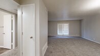 This single-story, 2-bedroom, 2-bathroom unit offers a practical and comfortable layout designed to maximize everyday living. The living room is generously sized, featuring soft carpeting, neutral-toned walls, a textured ceiling, and a set of French doors fitted with blinds that allow natural light to flow in. An adjacent dining area is accented by a modern chandelier, adding a refined touch to the space.

The kitchen is well-equipped with white shaker-style cabinetry, granite-look countertops, a grey subway tile backsplash, and light wood-look flooring. Stainless steel appliances — including a range, dishwasher, and refrigerator — complete the functional cooking space.

The primary bedroom is spacious, with plush carpeting, a large closet, and a bright window with blinds. The second bedroom is similarly finished with carpet and a window that brings in natural light. Both bedrooms offer a calm, neutral aesthetic suited for restful living.

Each bathroom features white cabinetry with granite-look countertops, an undermount sink, wood-look tile flooring, and a tub-shower combination with white tile surround. Built-in shelving provides additional storage. Throughout the unit, a cohesive palette of soft greys and whites creates a clean, move-in-ready environment.