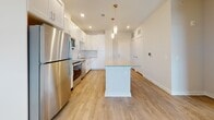 This single-floor residence at 101 Ascend Loop in Myrtle Beach, South Carolina, offers a clean, contemporary design with thoughtfully selected finishes throughout. The open-concept kitchen serves as a central highlight, featuring crisp white shaker cabinets, granite countertops, a subway tile backsplash, and a full suite of stainless steel appliances including a refrigerator, range, microwave, and dishwasher. A central island with a granite surface and pendant lighting above adds both function and style, while light wood-look flooring ties the space together seamlessly.

The living area extends naturally from the kitchen and is bathed in natural light from multiple windows and a glass door that opens to a private balcony. A ceiling fan adds comfort, and a smart home thermostat panel is conveniently mounted near the entry.

The bedrooms are carpeted for warmth and comfort, each equipped with ceiling fans and generous window coverage that invites ample natural light. The spacious walk-in closet features multi-tier wire shelving, providing excellent storage capacity.

The bathroom is well-appointed with white cabinetry, granite countertops, a framed glass walk-in shower, and wood-look flooring that mirrors the rest of the home. The overall aesthetic is bright, neutral, and move-in ready, making this Myrtle Beach residence an inviting and functional living space.