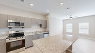 Located at 5391 W Fayetteville Rd in College Park, GA, this 2-bedroom, 1-bathroom unit offers a thoughtfully designed single-level layout that maximizes every square foot. The open-concept kitchen is a standout feature, showcasing granite countertops, gray cabinetry, and a full suite of stainless steel appliances including a refrigerator, range, microwave, and dishwasher. A generous kitchen island provides additional prep and dining space, flowing naturally into the living area, which is fitted with a ceiling fan and natural light from a nearby window. Light wood-tone flooring runs throughout the main living areas, lending a clean, contemporary feel. The spacious primary bedroom features plush carpeting, a ceiling fan, and a window that brings in natural light. It connects directly to the bathroom, which includes a granite-topped vanity with dark cabinetry, wood-look flooring, and access to a dedicated walk-in closet outfitted with multi-tier wire shelving. The second bedroom also offers carpeted floors, a ceiling fan, and two windows that fill the room with daylight. Neutral warm-gray tones throughout create a cohesive and inviting atmosphere across the entire unit.