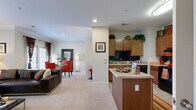 This thoughtfully designed single-floor residence offers a comfortable and functional layout across its 1 bedroom and 1 bathroom. The open-concept living and kitchen area forms the heart of the home, where plush carpeting flows through the living space and connects seamlessly to the dining area. The living room is bathed in natural light through large windows and features elegant crown molding, adding a refined architectural touch. A tiled entryway with a dedicated foyer provides a clean transition into the main living space.

The kitchen is well-equipped with warm wood cabinetry, a dark subway tile backsplash, black appliances including a gas range and dishwasher, and a central island that offers additional prep space and casual seating. Light tile flooring runs throughout the kitchen, complementing the overall design.

The bedroom is a comfortable retreat with carpeted floors, windows that let in ample natural light, and access to a spacious walk-in closet featuring multi-level wire shelving for generous storage. The full bathroom includes a tiled shower-tub combination and tile flooring.

A dedicated laundry room with wire shelving overhead and washer/dryer hookups completes this practical and well-rounded residence.