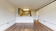 Located at 18 Old Ridgebury Road in Danbury, CT, this one-bedroom, one-bathroom unit offers a practical and well-appointed single-floor layout. The open-concept kitchen and living area serves as the heart of the unit, featuring a peninsula with light stone countertops, an undermount sink, and a full suite of stainless steel appliances including a refrigerator, range, microwave, and dishwasher. Gray shaker-style cabinetry provides ample storage, while warm hardwood-style flooring flows seamlessly throughout the space. The generously sized bedroom receives natural light through a large sliding window overlooking lush greenery, creating a calm and airy atmosphere. Accessibility-friendly grab rails run along the walls in the living and bedroom areas. The bathroom is finished with a floating granite-topped vanity, a large mirror, tile flooring, and a walk-in shower. A dedicated laundry area houses an in-unit front-loading washer, adding everyday convenience. Two closets offer additional storage throughout the unit. Clean white walls, consistent flooring, and a functional layout make this a well-organized and comfortable living space.