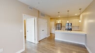 Located at 125 McKinley St in Angola, Indiana, this thoughtfully designed one-bedroom, two-bathroom unit offers a modern and efficient layout finished with contemporary details throughout. The open-concept living and kitchen area serves as the heart of the space, where a sleek peninsula with a white quartz countertop and an integrated sink anchors the room. Three stylish pendant lights hang above, complementing the recessed lighting and cream-toned cabinetry. Stainless steel appliances — including a refrigerator, range, and microwave — along with a classic subway tile backsplash complete the kitchen's polished look. Wood-look plank flooring runs throughout the entire unit, providing a warm and cohesive aesthetic. The bedroom is a well-proportioned retreat featuring a large window with blinds that invites natural light and offers views of the surrounding area. A double-door closet provides ample storage. Both bathrooms are clean and functional, each equipped with a tub-shower combination, modern vanities with white countertops, and consistent wood-look flooring. One bathroom features a walk-in closet area with built-in shelving, adding practical storage to the space. Warm beige walls and white trim throughout create a bright, neutral backdrop well-suited to a variety of personal styles.