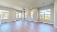 Located at 902 N Academy Ave in New Braunfels, TX, this three-story home offers a well-designed layout across three thoughtfully organized floors. The ground level includes a garage with vaulted ceiling and utility access, providing a practical entry point to the home. A welcoming entryway with hardwood-style flooring and a stylish staircase with dark metal railings leads to the main living floor. The central floor serves as the heart of the home, featuring an open-concept living room, dining area, and kitchen. The kitchen is a standout space, outfitted with white shaker cabinetry, a granite-topped island with pendant lighting, stainless steel appliances, and a subway tile backsplash. Large windows flood the living area with natural light and offer views of surrounding greenery, while a ceiling fan adds comfort. A pantry and a full bathroom complete this level. The upper floor hosts all three bedrooms, including a spacious primary suite with its own closet and en-suite bathroom. The additional bedrooms feature plush carpet, ceiling fans, and ample natural light. Three closets and a dedicated laundry room add to the home's functional appeal. Throughout, neutral tones, clean finishes, and modern matte-black hardware create a cohesive, contemporary aesthetic.