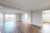 Located at 190 N Shore Rd in Revere, MA, this well-appointed 2-bedroom, 2-bathroom residence offers a thoughtfully designed single-floor layout with an open, airy feel throughout. The expansive living room is a standout feature, showcasing warm hardwood-style flooring, elegant crown molding, decorative column accents, and track lighting. Large sliding glass doors lead to a private balcony, flooding the space with natural light and providing pleasant outdoor views. The kitchen is outfitted with shaker-style cabinetry, white quartz countertops, a subway tile backsplash, and stainless steel appliances including a refrigerator and dishwasher. The generously sized primary bedroom features dual windows that bring in ample natural light, while the second bedroom offers its own window with scenic tree-lined views and stylish wall sconces. Both bedrooms are finished with the same hardwood-style flooring seen throughout the home. The two bathrooms are cleanly designed, with one featuring a glass-enclosed walk-in shower with neutral tile surround and modern vanity fixtures. Three closets provide excellent storage throughout. Soft sage-green and neutral tones create a calm, cohesive ambiance across all rooms.