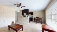 This single-floor, 1-bedroom, 1-bathroom unit offers a functional and well-organized layout. The open-concept living and dining area serves as the heart of the space, featuring large neutral-toned ceramic tile flooring that runs consistently throughout. A ceiling fan with integrated lighting provides both airflow and illumination to the main living area, which is defined by warm beige walls that create an inviting atmosphere.

The kitchen is designed in a galley configuration, showcasing dark espresso cabinetry paired with granite-style countertops and a tile backsplash. Black appliances, including a refrigerator, electric range, and microwave, complement the cabinetry for a cohesive look. A half-wall peninsula separates the kitchen from the living and dining space, offering a visual connection between the two areas while maintaining distinct zones.

The bedroom is a generously proportioned room with the same light tile flooring, warm beige walls, and its own ceiling fan. A window fitted with horizontal blinds allows for natural light and ventilation. An adjacent doorway leads to a closet, adding practical storage to the room.

The overall layout is straightforward and efficient, making effective use of the available square footage. The consistent flooring and neutral color palette throughout the unit create a cohesive, clean aesthetic that is easy to personalize.