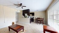 This single-floor, 1-bedroom, 1-bathroom unit offers a functional and well-organized layout. The open-concept living and dining area serves as the heart of the space, featuring large neutral-toned ceramic tile flooring that runs consistently throughout. A ceiling fan with integrated lighting provides both airflow and illumination to the main living area, which is defined by warm beige walls that create an inviting atmosphere.

The kitchen is designed in a galley configuration, showcasing dark espresso cabinetry paired with granite-style countertops and a tile backsplash. Black appliances, including a refrigerator, electric range, and microwave, complement the cabinetry for a cohesive look. A half-wall peninsula separates the kitchen from the living and dining space, offering a visual connection between the two areas while maintaining distinct zones.

The bedroom is a generously proportioned room with the same light tile flooring, warm beige walls, and its own ceiling fan. A window fitted with horizontal blinds allows for natural light and ventilation. An adjacent doorway leads to a closet, adding practical storage to the room.

The overall layout is straightforward and efficient, making effective use of the available square footage. The consistent flooring and neutral color palette throughout the unit create a cohesive, clean aesthetic that is easy to personalize.
