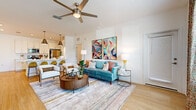 Located at 11032 Vida Cir in Bradenton, Florida, this single-story home presents a clean, contemporary design with a cohesive aesthetic carried throughout every room. Light wood-look flooring runs continuously across the open-concept living areas, complementing the crisp white walls and creating a warm, airy atmosphere.

The living room serves as the heart of the home, featuring a ceiling fan, generous wall space for artwork, and a seamless flow toward the kitchen. Natural light filters in through slatted blinds, enhancing the bright, welcoming ambiance. The kitchen is well-appointed with white shaker-style cabinetry, light quartz countertops, a subtle pale blue tile backsplash, and a full suite of stainless steel appliances. Double doors provide access to additional storage, and pendant lighting adds a refined touch overhead.

The bedrooms maintain the home's light palette, each offering wood-look flooring, ceiling fans or overhead lighting, and access to closet space. One bedroom includes a walk-in closet. The bathrooms are finished with white vanity cabinetry, clean countertops, and wood-look flooring. One bathroom features a glass-enclosed walk-in shower, while another offers a vanity with ample storage. The overall design is cohesive, modern, and move-in ready.
