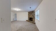 Located at 348 Tall Oaks Dr in Conyers, Georgia, this single-floor, one-bedroom, one-bathroom residence offers a thoughtfully arranged layout across a comfortable footprint. The living room serves as the heart of the home, anchored by a striking floor-to-ceiling natural stone fireplace with a raised hearth — a standout architectural feature that adds warmth and character to the space. Carpet flooring runs throughout the living areas and bedroom, while a window brings in natural light and views of the surrounding greenery. The kitchen is well-equipped with gray cabinetry lining both sides of the galley-style layout, white appliances including an electric range, refrigerator, and dishwasher, and light countertops. A peninsula with a double sink extends toward the living area, creating an open, connected feel. The kitchen also provides access to a dedicated utility room. The spacious primary bedroom is generously sized, featuring plush carpet, a natural light window, and convenient access to the full bathroom. The bathroom is clean and functional, outfitted with a tub/shower combination, light wood-look flooring, a gray vanity, and stone-look countertops. Textured ceilings are found throughout, lending a classic residential feel to the entire home.