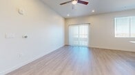 Located at 17645 N Porter Rd in Maricopa, AZ, this single-story, one-bedroom, one-bathroom unit offers a bright and clean modern layout. The open-concept kitchen and living area serves as the heart of the home, featuring crisp white shaker cabinetry, white quartz countertops, a central island, and a full suite of stainless steel appliances including a refrigerator, gas range, microwave, and dishwasher. Light wood-style flooring runs throughout the main living areas, enhancing the airy, contemporary feel. The living room benefits from recessed lighting, a ceiling fan, and a sliding glass door with vertical blinds that opens to a private balcony, allowing natural light to pour in. The bedroom is comfortably sized, finished with plush carpeting, a ceiling fan, natural light from a window with blinds, and direct access to a dedicated closet with built-in shelving. The bathroom is clean and functional, offering a full soaking tub with floor-to-ceiling white tile surround and modern chrome fixtures. Additional features include a hallway with two closets, a dedicated laundry area, and a welcoming entrance. The overall aesthetic is neutral, modern, and move-in ready.