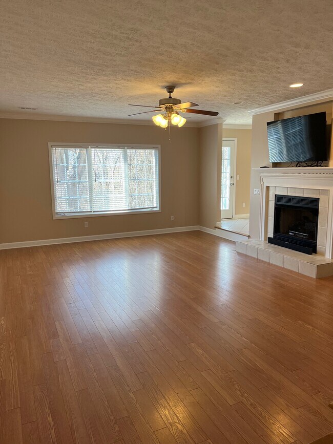 Sala de estar en la planta baja con chimenea y televisión. Pequeño patio exterior. - 2233 Whitney Ct