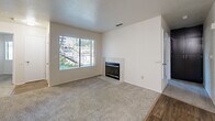 This single-story, 2-bedroom, 2-bathroom residence in Carmichael, California offers a practical and comfortable layout. The living room serves as the centerpiece of the home, featuring a tile-surround fireplace, plush carpet flooring, a ceiling fan, and a large window that fills the space with natural light. The adjacent dining area transitions seamlessly into the kitchen, which is equipped with dark espresso cabinetry, light countertops, a tile backsplash, a double-basin sink, black appliances including a range and refrigerator, a dishwasher, and a peninsula for added prep and seating space. Wood-look flooring runs throughout the kitchen and dining areas. Both bedrooms are carpeted and well-sized, with ample closet storage — five closets in total throughout the home. The primary bedroom includes a sliding glass door leading to the private patio, offering a seamless indoor-outdoor connection. The second bedroom also features a sliding glass door with outdoor access. Each bathroom includes a shower-tub combo and wood-look tile flooring. Additional highlights include a dedicated laundry area and a utility room, rounding out this efficiently designed home.