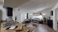 This single-floor residence offers a thoughtfully designed layout that balances comfort and functionality across its main living areas, bedrooms, and bathrooms. The open-concept living room flows seamlessly from the kitchen, featuring durable wood-look flooring, white walls, and a textured ceiling. The living area is well-lit with wall-mounted lighting and benefits from natural light streaming through windows dressed with layered curtains. A private exterior door in the living space provides convenient direct access.

The kitchen is a standout feature, equipped with dark espresso cabinetry, granite-style countertops, stainless steel appliances including a range and refrigerator, and an under-cabinet range hood. In-unit laundry is accessible directly from the kitchen area, adding everyday convenience.

The bedrooms are carpeted for comfort, each featuring windows with blinds that allow for natural light and privacy. The primary bedroom includes a ceiling fan, a walk-in closet, and a dedicated en-suite bathroom. The bathrooms are finished with granite-style vanity countertops, wood-look flooring, large mirrors, and shower-tub combinations, with built-in shelving for added storage. The overall design presents a clean, neutral palette that creates a warm and inviting atmosphere throughout.