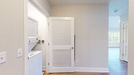 Located at 23 Station Rd in Brookfield, CT, this two-story home offers a thoughtfully designed layout across two floors. The main level provides a generous footprint, anchored by an open kitchen and living area. The kitchen is a standout feature, equipped with stainless steel appliances, dark granite countertops, white shaker cabinetry, a large center island with pendant lighting, and warm hardwood flooring throughout. The living room is particularly impressive, boasting vaulted ceilings, recessed lighting, and multiple large windows that invite abundant natural light and outdoor views of the surrounding greenery.

The upper level hosts the bedrooms, including a well-proportioned primary bedroom featuring vaulted ceilings, large windows with outdoor views, and hardwood floors. The second bedroom is finished with hardwood floors and neutral-toned walls. Both bathrooms are cleanly appointed with LED-lit vanity mirrors, white countertops, and hardwood flooring. A convenient stacked washer and dryer unit is incorporated into the layout. A staircase connects the two levels, completing this cohesive and modern home.