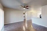 Located at 920 N Woodland St in Visalia, California, this single-floor home offers a well-designed, open-concept layout that balances comfort and functionality. The living area features wood-look flooring, neutral-toned walls, and a ceiling fan with light fixture, creating a bright and airy atmosphere. A sliding glass door allows natural light to flow in while providing access to the outdoors. The adjacent dining area is defined by an elegant chandelier overhead and continues the same warm flooring. The kitchen is a standout feature, equipped with crisp white shaker-style cabinetry, granite-look countertops, and a full suite of black appliances including a refrigerator, range, microwave, and dishwasher. A peninsula with a sink adds additional workspace and casual seating potential. The bedrooms are carpeted for comfort, each outfitted with a ceiling fan, and offer generous closet space. One bedroom includes direct access to a hallway with additional storage. The bathroom is finished with tile flooring, white cabinetry topped with granite counters, a large mirror, and a tub-shower combination with a window for natural ventilation. Throughout the home, consistent finishes and neutral tones create a cohesive and move-in ready environment.