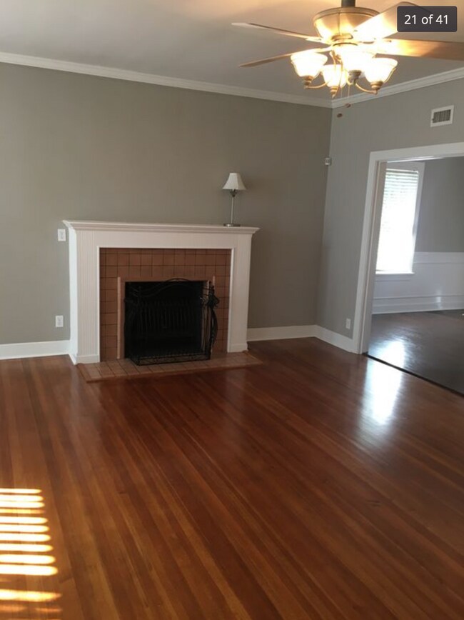 View from the front door walking into the living room. Real hardwood floors. (The fireplace is decoration only- does not work) - 214 S Bishop St