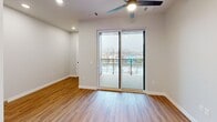 This 370 square foot apartment in New London, WI, offers a thoughtful layout maximizing its compact space. The modern kitchen is a standout feature, boasting light wood cabinetry, stainless steel appliances, and a clean white subway tile backsplash. The kitchen is equipped with a full-size refrigerator, built-in microwave, electric range, and dishwasher, providing all essential amenities.

The living area, while modest in size, is brightened by a large sliding glass door leading to a private balcony, offering views of the surrounding area and allowing natural light to flood the space. The room features recessed lighting and a ceiling fan for added comfort.

The bathroom continues the modern aesthetic with a light wood vanity, white countertop, and matching floor-to-ceiling tilework. Wood-look laminate flooring runs throughout the apartment, creating a cohesive and warm ambiance.

A closet provides additional storage space, crucial in a compact living environment. The apartment's efficient design makes excellent use of its 370 square feet, creating a comfortable and functional living space that belies its small footprint.