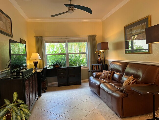 Estudio con sillón reclinable doble de cuero, escritorio y televisor. - 329 NW Treeline Trce