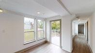 Located at 127 Fourth Ave in Dayton, Kentucky, this single-floor unit offers a clean, contemporary interior defined by a neutral color palette, wood-look flooring, and an abundance of natural light. The open living area is generously proportioned, featuring a ceiling fan, recessed lighting, and large windows that frame views of the surrounding greenery. A glass door leads directly to a private outdoor deck, extending the living space and providing pleasant outdoor access.

The kitchen is well-appointed with white shaker-style cabinetry, a white subway tile backsplash, light quartz countertops, and a full suite of stainless steel appliances including a refrigerator, dishwasher, microwave, and range. A center island provides additional prep and dining space.

The bedrooms are comfortably sized, each finished with wood-look flooring and ceiling fans. One bedroom includes access to a walk-in closet area and an adjacent bathroom. Two full bathrooms serve the unit: one features a walk-in shower with clean white surround, while the other includes a soaking tub with shower combination. Both bathrooms are finished with white cabinetry and consistent, modern fixtures. The overall ambiance is fresh, light-filled, and move-in ready.