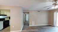 Located at 700 N Spence Ave in Goldsboro, NC, this single-floor unit offers a well-organized layout with consistent warm-toned finishes throughout. The living area serves as a welcoming focal point, featuring a wood-burning fireplace with a classic surround, a ceiling fan with integrated lighting, and durable wood-look plank flooring that extends throughout the entire unit. Neutral beige walls and white baseboards create a clean, cohesive aesthetic.

Adjacent to the living area, a dedicated dining space is highlighted by a chandelier, adding a touch of elegance. The galley-style kitchen is efficiently designed with white cabinetry, light countertops, a stainless steel sink, and a full suite of black appliances including an electric range, refrigerator, and dishwasher. A central hallway connects the main living spaces to the private areas of the unit, including a bedroom that receives natural light through a window with blinds. The full bathroom is outfitted with a vanity featuring white cabinetry, a toilet, and a tub and shower combination enclosed by a clean white surround. Louvered closet doors add a classic touch. The textured ceilings and ceiling-mounted HVAC vents are present throughout, contributing to functional, comfortable living.