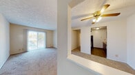 Located at 6162 White Oak Dr in Florence, Kentucky, this single-story residence offers a practical and well-organized layout designed for comfortable everyday living. The living area serves as the heart of the home, featuring neutral-toned carpet, a ceiling fan with integrated lighting, and a sliding glass door fitted with vertical blinds that allows natural light to fill the space. A half-wall partition subtly separates the living area from adjacent spaces, adding architectural definition without closing off the floor plan.

The galley-style kitchen is equipped with warm-toned wood cabinetry, laminate countertops, hardwood-style flooring, and a black refrigerator. Ample upper and lower cabinet storage lines both sides of the kitchen, providing generous workspace and organization. A passthrough opening connects the kitchen visually to the living and dining areas.

A carpeted hallway leads to multiple bedrooms, each finished with neutral carpet, textured ceilings, and windows that bring in outside views and natural light. The bedrooms offer functional space suitable for varied uses.

Two bathrooms serve the residence. One features a tub-shower combination with white tile surround, a vanity with white cabinetry, and a large mirror. The second bathroom includes hardwood-style flooring, a single-sink vanity, and clean, understated finishes throughout. The overall ambiance is neutral, tidy, and move-in ready.