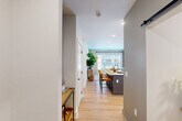 Located at 68 River St in Chattanooga's North Shore neighborhood, this thoughtfully designed one-bedroom, one-bathroom residence offers a smart and efficient layout across a single floor. Light oak hardwood flooring flows seamlessly throughout, tying each space together with a warm, cohesive aesthetic.

The open-concept kitchen and living area serves as the heart of the home. The kitchen features white shaker cabinetry with gold hardware, a subway tile backsplash, stainless steel appliances including a French door refrigerator and gas range, and a central island with a quartz countertop and bar seating — ideal for casual dining or entertaining. The living area is bathed in natural light from large windows offering neighborhood views, and is anchored by a distinctive sage green accent wall.

The bedroom is a serene retreat, featuring a ceiling fan, a bold charcoal accent wall, and a generous window that brings in natural light and outdoor views. Two closets provide ample storage, and a dedicated office space adds versatile functionality.

The bathroom is clean and modern, with a frameless glass shower featuring white subway tile and matte black fixtures. A stacked in-unit washer and dryer sits conveniently adjacent, with direct access to the walk-in closet completing a well-organized private wing. A sliding barn door adds a stylish architectural touch.