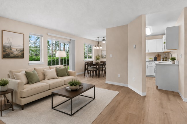 A bright, open living and dining space with abundant natural light, direct patio access, and a comfortable layout for relaxing or entertaining. - Crossroads at Meridian Apartments