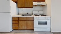 Located at 2555 Old Trevose Rd in Feasterville Trevose, PA, this single-floor unit offers a practical and straightforward layout comprising a living room, kitchen, and full bathroom. The living room is finished with wall-to-wall carpeting and neutral beige walls, creating a clean and adaptable space. A large sliding glass door allows natural light to fill the room while providing access to an outdoor area. Baseboard heating runs along the walls, ensuring consistent warmth throughout. The kitchen features warm-toned oak cabinetry — both upper and lower — paired with a white laminate countertop, a stainless steel sink, and a white gas range with an overhead exhaust hood. The flooring transitions to a hard surface in this area, adding a functional contrast to the living space. The bathroom is tiled in classic white from floor to ceiling, with a full-sized soaking tub and shower combination. The space maintains a consistent, understated aesthetic throughout, with white walls and simple finishes that provide a versatile canvas. The unit is compact in scale, making it efficient and easy to maintain, and is well-suited for a single occupant or couple.