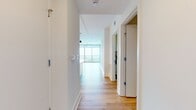 This well-designed apartment maximizes its 950 square feet of living space, offering a comfortable and modern home. The layout includes two bedrooms, two bathrooms, and an open-concept kitchen and living room area. The primary bedroom is generously sized at 170 square feet, providing ample space for relaxation.

The interior is characterized by its bright and airy atmosphere, achieved through the use of white walls that reflect natural light. The flooring throughout is a light-toned wood, adding warmth and visual continuity to the space. This choice of materials creates a clean, contemporary aesthetic that makes the apartment feel spacious and inviting.

The open-plan design of the main living area allows for flexible use of space and promotes a sense of flow between the kitchen and living room. This layout is ideal for entertaining or for everyday living, offering a seamless transition between cooking, dining, and relaxation areas.

Storage needs are addressed with two closets, ensuring that residents have sufficient space to keep their belongings organized. The inclusion of two bathrooms adds convenience and privacy, especially valuable in a two-bedroom setting.

Overall, this apartment combines efficient space utilization with modern design elements, creating a welcoming home that balances functionality with style.