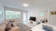Located at 6208 SW 59th Pl in South Miami, FL, this 2-bedroom, 1-bathroom single-story home offers a clean, modern aesthetic throughout. The interior is defined by crisp white walls, light wood-toned flooring, and a bright, airy atmosphere enhanced by multiple windows framing lush greenery views.

The living area serves as the heart of the home, combining a comfortable seating space with a dining area. A large window and private exterior door flood the room with natural light, creating an open and welcoming ambiance. The kitchen is efficiently designed, featuring stainless steel appliances, a decorative patterned tile backsplash, and white cabinetry.

The primary bedroom is well-proportioned, offering two windows with garden views, light wood flooring, and ample space for a desk area — ideal for both rest and productivity. The second bedroom is equally bright, featuring a closet and a window, with the same consistent light and clean design language.

The bathroom is stylishly appointed with large-format white wall tiles, a patterned mosaic floor, a glass-enclosed walk-in shower, and an industrial-style open shelving unit that adds a contemporary touch.

A connecting hallway links all rooms efficiently, completing this well-organized and move-in-ready South Miami home.