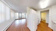 Located in the heart of Calgary, AB, this one-bedroom, one-bathroom unit offers a practical and well-organized layout across a single floor. Warm hardwood-style flooring runs throughout the main living areas, lending a consistent and inviting look to the space.

The open-plan living and dining area is bathed in natural light, courtesy of large floor-to-ceiling sliding glass doors that lead directly to a private balcony. From the balcony, residents enjoy open views of Calgary's downtown skyline, making it a notable feature of the unit. The living area is spacious enough to accommodate comfortable seating and a dining setup side by side.

The kitchen is efficiently designed with white cabinetry extending to the ceiling for ample storage, white appliances including a refrigerator and electric range, and a dedicated dining area with pendant lighting nearby. A functional corridor connects the main living space to the private areas of the unit.

The bedroom is a comfortable, well-lit room featuring a large window with vertical blinds that filter natural light and offer city views, along with a sliding-door closet for storage. The full bathroom includes a tiled shower-tub combination, vanity with mirror, and tile flooring. The unit also features a dedicated entrance area for added convenience.