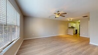 Located at 10035 Dabney Dr in Charlotte, NC, this two-floor home presents a clean, neutral aesthetic with thoughtfully updated finishes across both levels. The main living area is generously proportioned, showcasing light wood-style flooring, warm beige walls, white trim, and a ceiling fan with integrated lighting. The space flows naturally toward the kitchen, which features white shaker-style cabinetry, light quartz countertops, stainless steel appliances including a range and dishwasher, and light wood-look flooring that ties the common areas together cohesively.

The bedrooms offer plush carpeting, ceiling fans, and ample natural light through slatted windows. Several bedrooms include mirrored sliding closet doors, and one features a distinctive barn-style door, adding a modern touch. Vaulted ceilings in select rooms enhance the sense of volume and openness.

The bathrooms are well-appointed, with white cabinetry, brushed nickel hardware, and light countertops. The primary bathroom stands out with a double-sink vanity, a tiled walk-in shower with sliding glass doors, and wood-look flooring. A secondary bathroom includes a tub-shower combination and a single vanity with matching finishes. Throughout, the home maintains a consistent, updated palette that is both functional and visually cohesive.