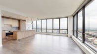 Located in Chicago's vibrant West Loop neighborhood, this single-floor high-rise residence offers a refined contemporary living experience defined by clean lines, premium materials, and breathtaking panoramic city views. Floor-to-ceiling windows wrap the open-concept living and dining area, flooding the space with natural light and framing expansive views of the Chicago skyline and surrounding neighborhoods. Light-toned hardwood flooring flows throughout, enhancing the bright, airy ambiance.

The chef's kitchen is outfitted with flat-front light oak cabinetry, stone countertops with a matching backsplash, stainless steel appliances including a gas cooktop and wall oven, and a built-in wine refrigerator — all centered around a generous island ideal for both prep and entertaining.

Bedrooms continue the floor-to-ceiling window theme, offering city views and ample built-in closet storage with custom shelving. A dedicated walk-in closet provides additional organization space. The bathrooms are thoughtfully designed: a full bath features a soaking tub, tiled shower with glass enclosure, and light wood-look flooring, while additional bathrooms showcase warm oak vanities with stone counters and sleek concrete-finish vanities with matte black fixtures. A well-organized corridor with louvered utility doors completes the layout.