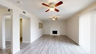 Located at 13050 W Cedar Dr in Lakewood, Colorado, this efficiently designed single-floor unit offers a well-organized layout comprising a living room, kitchen, hallway, and bathroom. The living room serves as the heart of the space, featuring a classic white-mantled fireplace, a ceiling fan with light fixture, a textured ceiling, and light-toned luxury vinyl plank flooring that runs throughout the entire unit. A large sliding glass door floods the room with natural light, creating a bright and open atmosphere. The kitchen is neatly appointed with white shaker-style cabinetry, granite-look countertops, a single-basin sink, and a full suite of white appliances including a refrigerator, electric range, and over-the-range microwave. The bathroom is clean and contemporary, offering a granite-top vanity with an undermount sink, a walk-in shower enclosed with dark-framed glass doors, built-in open shelving, and a mirrored medicine cabinet. Neutral, warm-toned walls throughout the unit complement the light flooring, contributing to a cohesive and inviting aesthetic. The thoughtful use of space and modern finishes make this unit a functional and comfortable home in the Lakewood community.