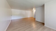 Located at 8501 Walther Blvd in Nottingham, MD, this single-floor, 2-bedroom, 1-bathroom home offers a clean, modern aesthetic throughout. The layout makes efficient use of its space, with distinct areas for living, dining, and sleeping.

The living room is a welcoming, open area finished with light wood-style flooring that runs throughout the main areas of the home. Large windows allow natural light to fill the space, creating a bright and airy atmosphere.

The kitchen is thoughtfully updated, featuring crisp white cabinetry, light countertops, a stainless steel sink, and a full suite of stainless steel appliances including a range, microwave, and dishwasher. A window above the dining area brings in additional natural light.

Both bedrooms are carpeted in a neutral tone, offering a comfortable and quiet retreat. The primary bedroom is generously sized and includes closet access, while the second bedroom also features a window with natural light. The clean white walls throughout provide a versatile, move-in-ready canvas.

The bathroom is well-appointed with a full soaking tub and shower combination, accented by warm beige tile surround and brushed nickel fixtures, complementing the home's consistent, updated style.
