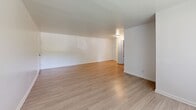 Located at 8501 Walther Blvd in Nottingham, MD, this single-floor, 2-bedroom, 1-bathroom home offers a clean, modern aesthetic throughout. The layout makes efficient use of its space, with distinct areas for living, dining, and sleeping.

The living room is a welcoming, open area finished with light wood-style flooring that runs throughout the main areas of the home. Large windows allow natural light to fill the space, creating a bright and airy atmosphere.

The kitchen is thoughtfully updated, featuring crisp white cabinetry, light countertops, a stainless steel sink, and a full suite of stainless steel appliances including a range, microwave, and dishwasher. A window above the dining area brings in additional natural light.

Both bedrooms are carpeted in a neutral tone, offering a comfortable and quiet retreat. The primary bedroom is generously sized and includes closet access, while the second bedroom also features a window with natural light. The clean white walls throughout provide a versatile, move-in-ready canvas.

The bathroom is well-appointed with a full soaking tub and shower combination, accented by warm beige tile surround and brushed nickel fixtures, complementing the home's consistent, updated style.